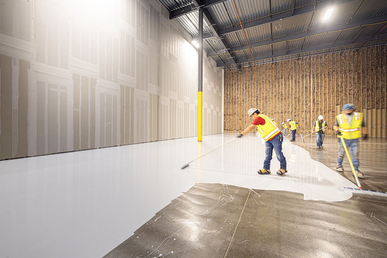 Mastering the First Impression: Your intriguing post title goes here Construction workers in hard hats and vests laying a fresh concrete floor inside a building in Dallas, Texas.
